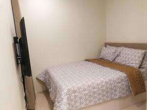 Dormitorio pequeño con cama y pared en Adria Residences - Emerald Garden - 2 Bedroom Unit for 4 person, en Manila