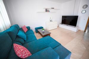 uma sala de estar com um sofá azul e uma televisão em Villa el Roque em Corralejo