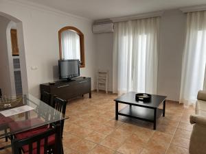 a living room with a television and a table at Apartamentos Jimmy 2 in Nerja