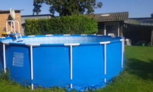 a blue pool in the yard of a house at Ferienwohnung Petersen-Kröger in Gelting