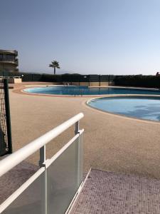 una piscina con una valla blanca al lado en Riviera de Bahia, en Villeneuve-Loubet