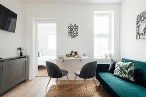 a living room with a green couch and a table at Unique 2 Bedroom Flat in Ilford, London in Ilford