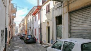 a street with cars parked on the sides of buildings at Welcomely - Sa Dommedda in Nuoro