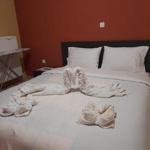Una cama blanca con toallas encima. en Apartment Mitrou en Loutra Oraias Elenis 