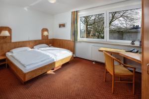 a bedroom with a bed and a desk and window at Academy Lodge Boardinghouse in Hamburg