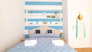 - une chambre avec un lit à rayures bleues et blanches dans l'établissement Welcomely - Casa Dei Marinai, à Putzu Idu