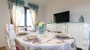 - une table blanche avec des assiettes et des verres dans l'établissement Welcomely - Casa Dei Marinai, à Putzu Idu