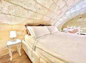 ナルドにあるCasa Dahliaの石の壁に大きなベッドが置かれた寝室