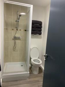 a bathroom with a shower and a toilet with a glass door at The Prince Alfred in Liverpool
