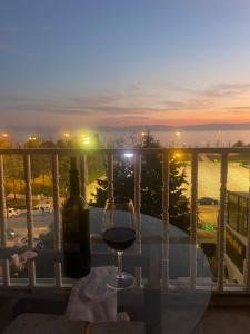 a glass of wine sitting on a table on a balcony at Suit tuzla in Tuzla
