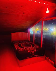 um quarto com uma cama com luz vermelha em Suit tuzla em Tuzla