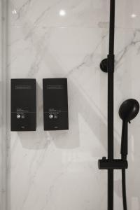 two black boxes on a white marble wall at Hygge House in Lisbon