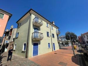 una mujer parada frente a un edificio en Trilocale vista mare con 2 bagni nel centro storico - Agenzia Cocal, en Caorle