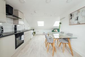 a kitchen with a table and chairs in a room at Contemporary 1 Bedroom Loft in Ilford, London in Ilford