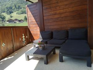 eine Terrasse mit 2 Sofas und einem Tisch in der Unterkunft The River Pearl in Val dʼIlliez