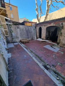 einen leeren Innenhof mit Ziegelwand und einem Gebäude in der Unterkunft L'Antre du Dragon in Marseille