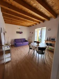 sala de estar con mesa y sofá púrpura en Lilla Apartment Residenza Silvana en Verbania