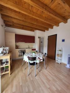 cocina y comedor con mesa y sillas en Lilla Apartment Residenza Silvana en Verbania