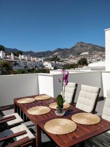 a wooden table on a balcony with chairs and a table at Benalmadena new terraced house 3 bedroom 2,5 bathroom in Benalmádena