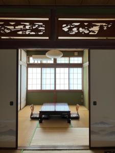 a room with a table in front of a window at Nakaya House in Miyajima
