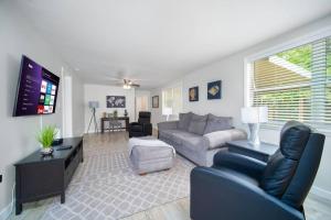 a living room with a couch and a tv at Fully Renovated house 10 min to Mayo Clinic in Jacksonville