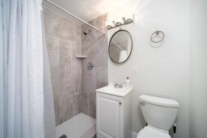a bathroom with a toilet and a shower with a mirror at Fully Renovated house 10 min to Mayo Clinic in Jacksonville