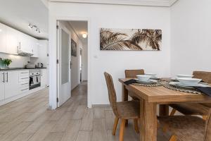 cocina y comedor con mesa de madera y sillas en Serenity, en La Mata