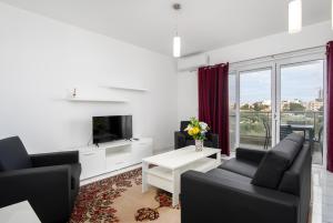 a living room with a couch and a tv and a table at Sea View Apartment 2 bedrooms 2 bathrooms, 2 minutes away from the sea in St Julian's