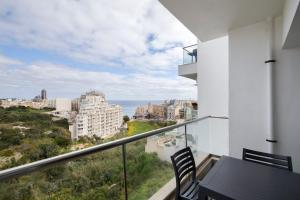 a balcony with a table and chairs and the ocean at Sea View Apartment 2 bedrooms 2 bathrooms, 2 minutes away from the sea in St Julian's