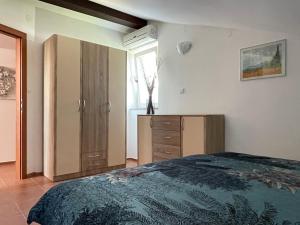a bedroom with a bed and a dresser and a window at Apartment Lady Daniela mit Meerblick in Lovran in Lovran