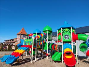 un parque infantil con un colorido equipo de juegos en Flaming - domki letniskowe en Rowy