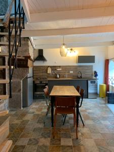 een keuken met een houten tafel en stoelen bij Charming typical stone house with modern amenities in Chauzon