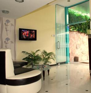 a living room with a glass door and a room with plants at hotel Harmony in Sunny Beach