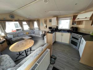 a kitchen and living room of an rv at Grouse 54, Scratby - California Cliffs, Parkdean, sleeps 6, pet friendly, bed linen, towels and Wi-Fi included in Scratby