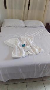 a white bed with a robe on it at Encanto do Beija-flor in Angra dos Reis
