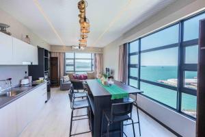a kitchen and living room with a large view of the ocean at HayBay Jesselton Quay Deluxe Seaview Suite 海景观 in Kota Kinabalu