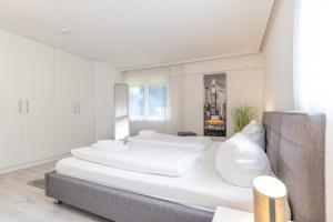 a white bedroom with two beds in it at Haus Alpsee in Immenstadt im Allgäu