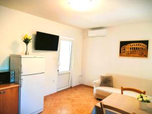 a living room with a couch and a tv on the wall at Apartment Karlo - city center in Pag