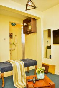 a living room with two beds and a table at Classic Studio Milimani - Wi-Fi and Parking in Kisumu