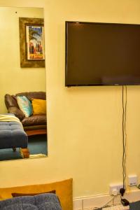 a living room with a flat screen tv on a wall at Classic Studio Milimani - Wi-Fi and Parking in Kisumu