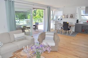 a living room with a couch and a table with flowers at Maison du Port in Timmendorfer Strand
