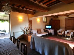 ein Wohnzimmer mit einem Tisch und Stühlen sowie einem TV in der Unterkunft Attractive apartment in Castiglione del Lago with pool in Castiglione del Lago