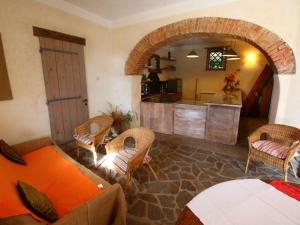 ein Wohnzimmer mit einem Sofa und einer Küche in der Unterkunft Attractive apartment in Castiglione del Lago with pool in Castiglione del Lago