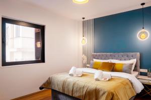 a bedroom with a large bed with a blue wall at EcoStay - Infinity business class 2BDR apartment by the sea in Alimos in Athens