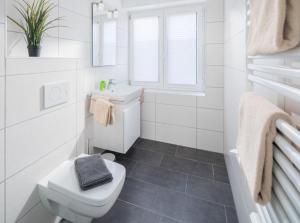 uma casa de banho branca com um WC e um lavatório em weitSicht em Norderney