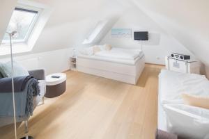 een witte woonkamer met een bank en een tv bij Villa Seegatt 7 in Norderney