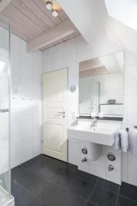 een witte badkamer met een wastafel en een spiegel bij Villa Seegatt 7 in Norderney