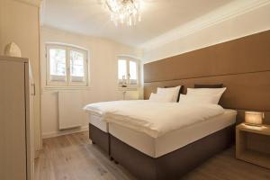 ein Schlafzimmer mit einem großen Bett und einem Kronleuchter in der Unterkunft Villa Vie 1 in Norderney