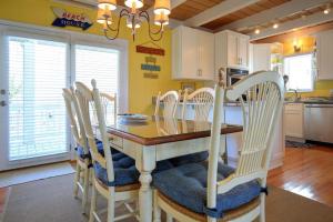 a kitchen with a wooden table with chairs around it at Holden Jeanie in Holden Beach
