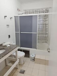 a bathroom with a toilet and a sink and a shower at Pousada Canto do Forte Pertinho da Praia do Tombo in Guarujá